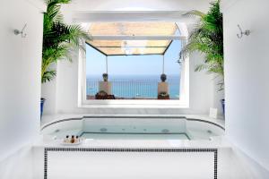 a bath tub in a room with a window at Hotel Marincanto in Positano