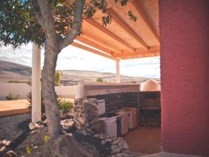 an outdoor kitchen with a tree in front of a house at Studio - Agua - Surf & Yoga Villa in La Pared
