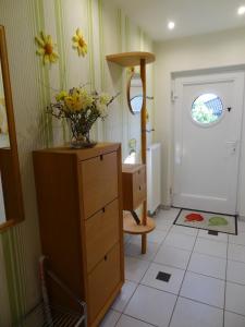 a bathroom with a dresser with a vase of flowers on it at Ruhe - Oase am Eichwald in Bad Nauheim