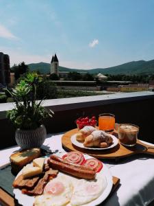 a table with a breakfast of eggs sausage and bread at Villa Marinko in Međugorje