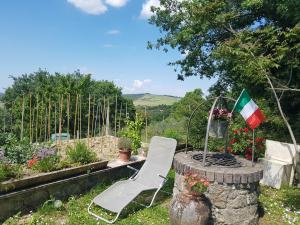 een stoel en een vlag in een tuin bij La Casa del susino in Castiglione dʼOrcia