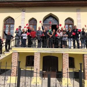 a group of people standing on the balcony of a building at Frig Evi in Sabuncu