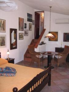 Pokój z łóżkiem, stołem i schodami w obiekcie Studio-Appartment in Landhaus mit Meerblick w mieście Porto Azzurro