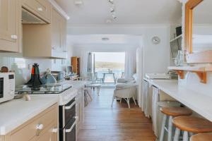 cocina con encimeras blancas y comedor en Falmouth View, en Falmouth
