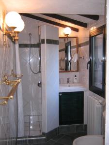 y baño con ducha y lavamanos. en Studio-Appartment in Landhaus mit Meerblick, en Porto Azzurro