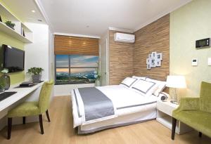 a bedroom with a bed and a desk with a computer at Good Morning Residence Hue in Daejeon