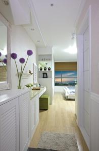 uma cozinha com armários brancos e flores roxas num quarto em Good Morning Residence Hue em Daejeon