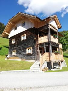a log house with a balcony on the side of it at Hochkirg Lehen in Donnersbach