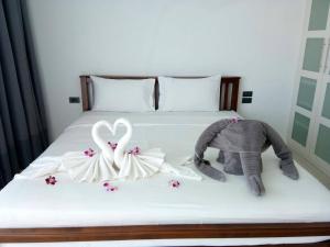 a bed with a stuffed elephant and a swan at villa Siam View Samui in Ban Bang Po