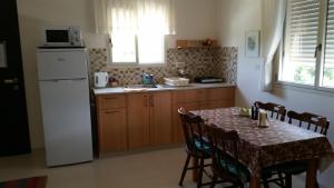 a kitchen with a table and a white refrigerator at Beit Haner Moshav Dor in Dor