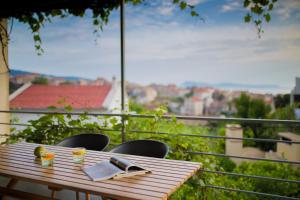 a wooden table with a book on top of a balcony at Apartments Zambarlin in Komiža
