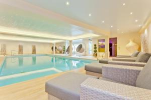 安布尔塞德Ambleside Salutation Hotel & Spa, World Hotel Distinctive的一个带椅子和沙发的房子内的游泳池