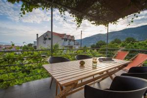 una mesa de madera y sillas en un balcón con vistas en Apartments Zambarlin, en Komiža