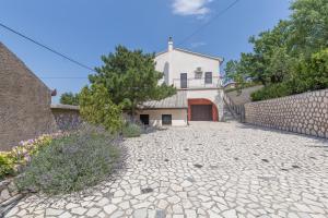 a stone driveway with a house in the background at Rooms Nada in Senj