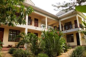 eine Außenansicht eines Gebäudes mit Bäumen und Pflanzen in der Unterkunft The Vijiji Center Lodge & Safari in Arusha