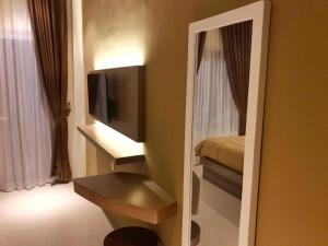 um espelho num quarto com uma televisão e uma cama em villa view2 sayriah em Puncak