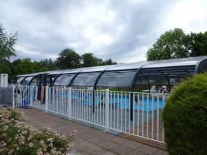 a glass building with a swimming pool in it at Camping La Pindière in Héric