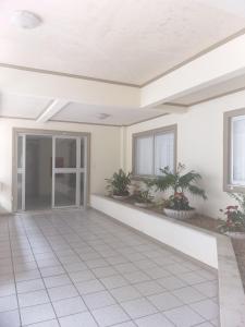 an empty room with potted plants in a house at Apto em ótima localização! in Lages