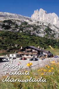 a large building in front of a mountain at Rifugio Fedaia in Malga Ciapela