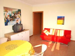 sala de estar con sofá rojo y TV en Nido sul Lago Maggiore en Maccagno Superiore
