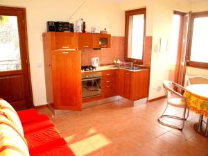 cocina con armarios de madera, fregadero y mesa en Nido sul Lago Maggiore en Maccagno Superiore