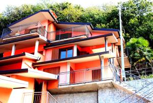 un edificio anaranjado con balcones en el lateral. en Nido sul Lago Maggiore en Maccagno Superiore
