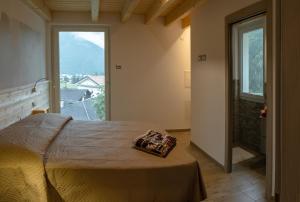 a bedroom with a bed and a large window at Residenza al Castello in Enguiso