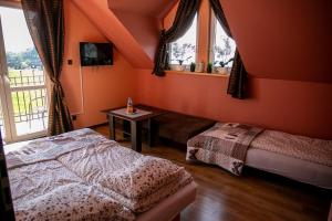 Schlafzimmer mit orangefarbenen Wänden, einem Bett und einem Tisch in der Unterkunft Apartamenty i Pokoje Gościnne Ala in Szklarska Poręba