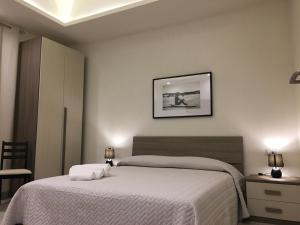 a bedroom with two beds and a picture on the wall at Dimora Conte in La Maddalena