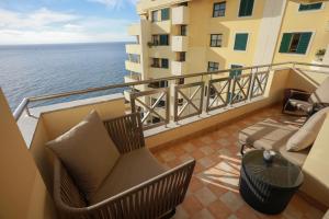 - un balcon avec une chaise et une table donnant sur l'océan dans l'établissement Marvelous Ocean View, à Funchal