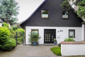 una casa en blanco y negro con una puerta negra en Messeapartment Sunny Side, en Düsseldorf