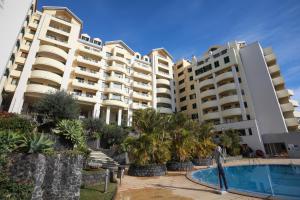 un grand immeuble avec piscine et palmiers dans l'établissement Marvelous Ocean View, à Funchal