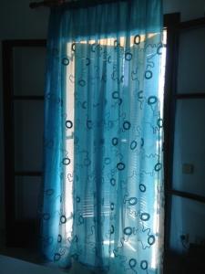 a window with a blue curtain with writing on it at Studios Petra in Kipseli