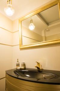 a bathroom with a sink and a mirror at Poseidon Luxury Apartment in Karpathos