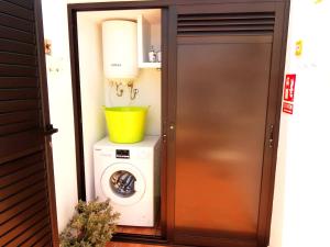 a laundry room with a washing machine and a yellow bucket at Mi Quíquere in Mácher