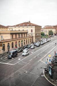 a city street with cars parked in front of buildings at Amendola Central Station in Bologna