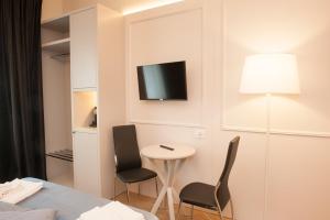 a room with two chairs and a table and a tv on the wall at Amendola Central Station in Bologna