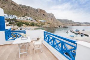 balcón con mesa y vistas al agua en Poseidon Luxury Apartment en Kárpatos