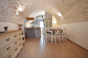 a kitchen and dining room with a table and chairs at La dimora di nonna Dora in Martina Franca