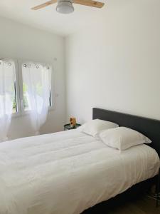 um quarto com uma grande cama branca com almofadas brancas em ALPS COCOON em Annecy