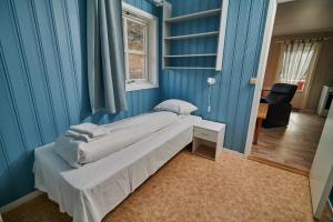 1 dormitorio con cama y pared azul en Skjervøy Lodge en Skjervøy