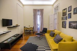 a living room with a yellow couch and a table at Casa da Matriz in Ponta Delgada