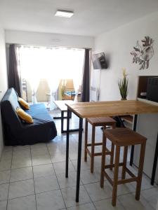 een woonkamer met een tafel en stoelen en een bank bij Le Vénizio in Sète