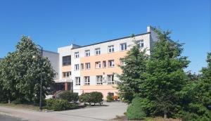 an apartment building with trees in front of it at Centrum Konferencyjne Brancon in Babimost