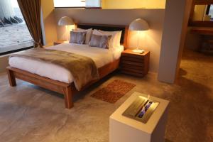 a bedroom with a large bed and a table at Pelican Point Lodge in Walvis Bay +36 photos