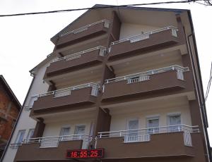 un edificio alto con balcones a un lado. en Apartmani Marić en Novi Pazar