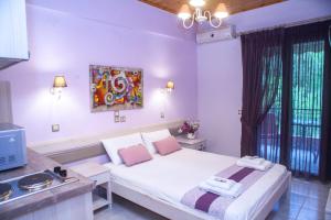 a bedroom with a white bed and a tv at Nontas Homes in Kalamitsi