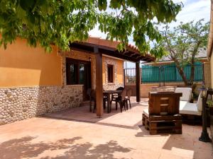 un patio al aire libre con mesa y sillas en La Casita Del Abuelo, en Villalmanzo
