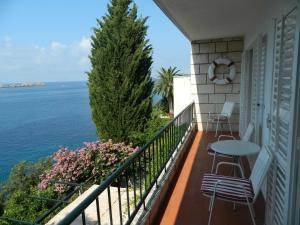 a balcony with a table and chairs and the ocean at Apartments Mercep in Dubrovnik