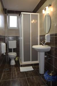 a bathroom with a toilet and a sink and a shower at Apartmani Marić in Novi Pazar +110 photos